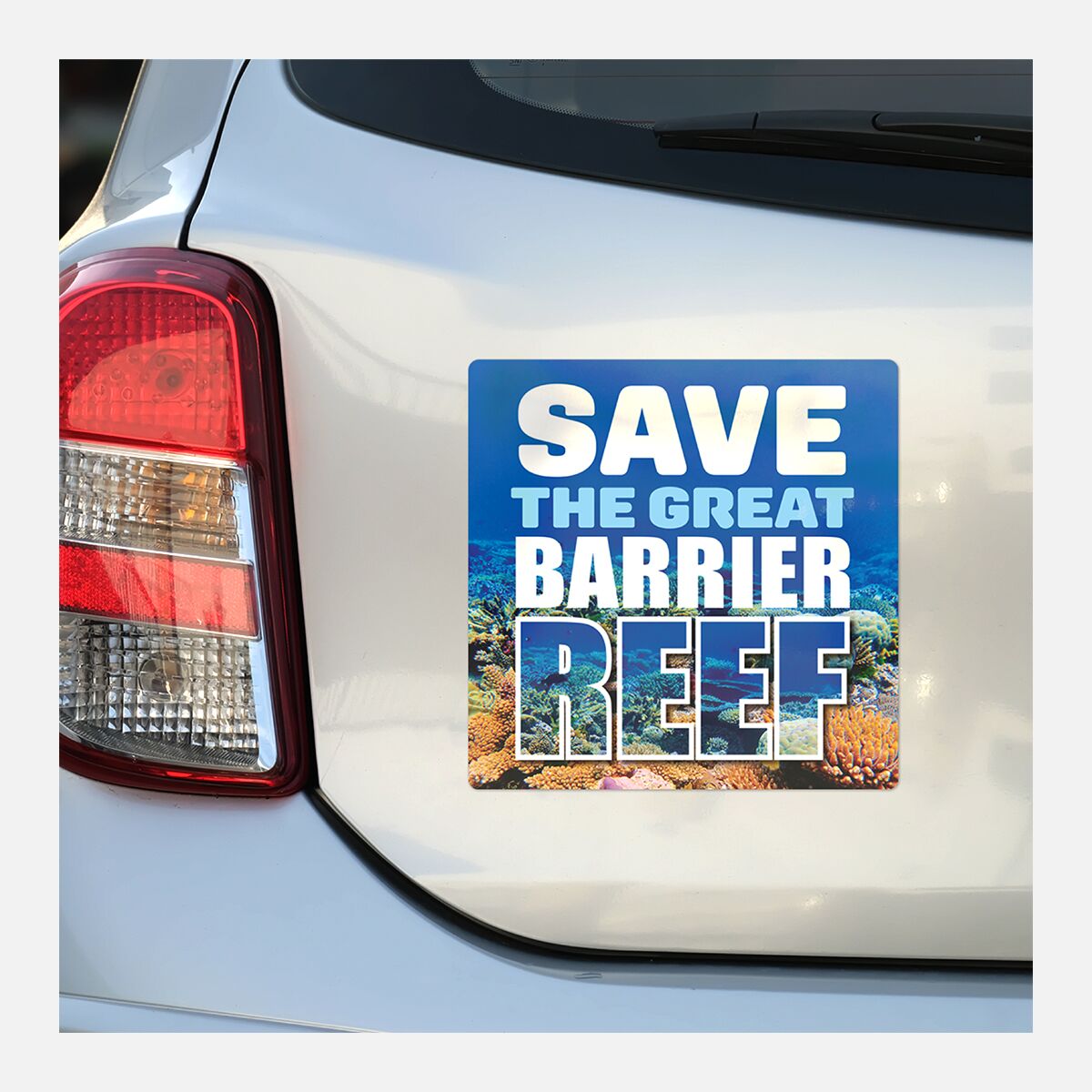 Square bumper sticker on the back of a white vehicle reading “Save the Great Barrier Reef”